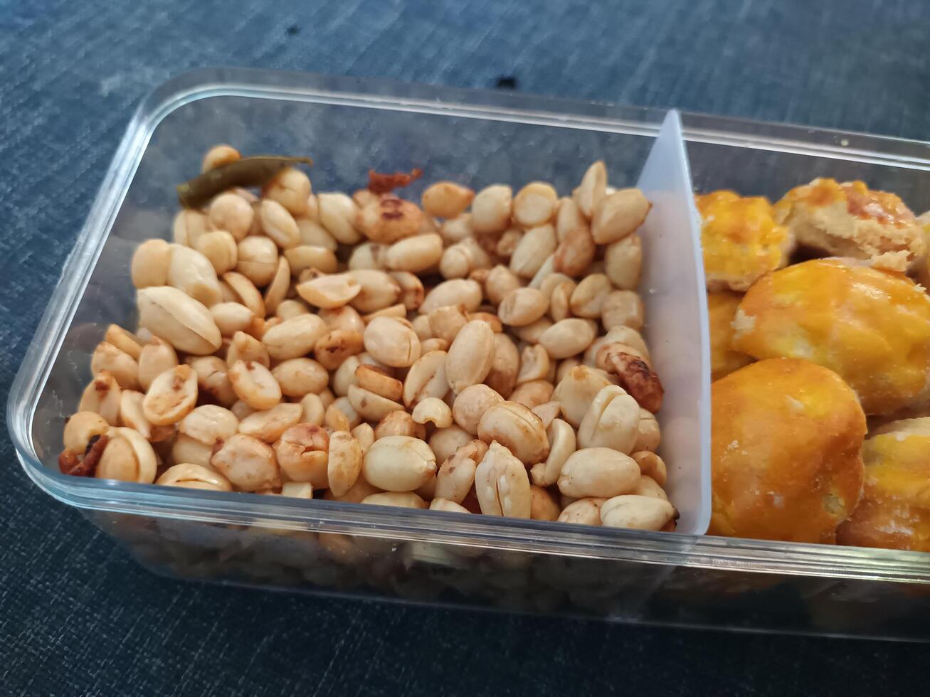 Roasted Peanuts and Pineapple Tarts in a Clear Compartment Container. photo