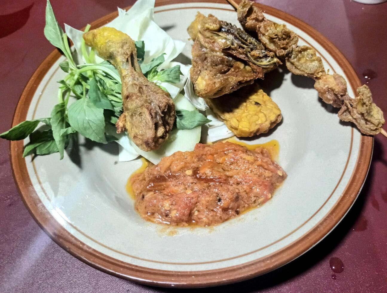 Pecel Lele Dish with Fried Catfish, Chicken, Tempeh, and Sambal photo