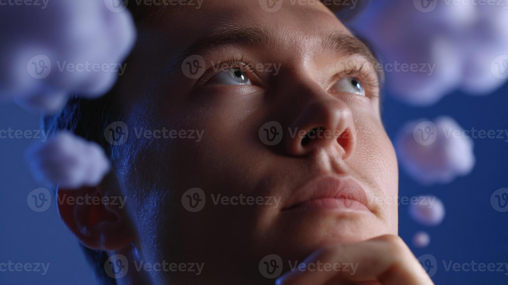 A closeup of a learners face illuminated by the soft glow of a computer screen portraying their deep contemplation. Surrounding them are abstract thought bubbles filled with tailore photo