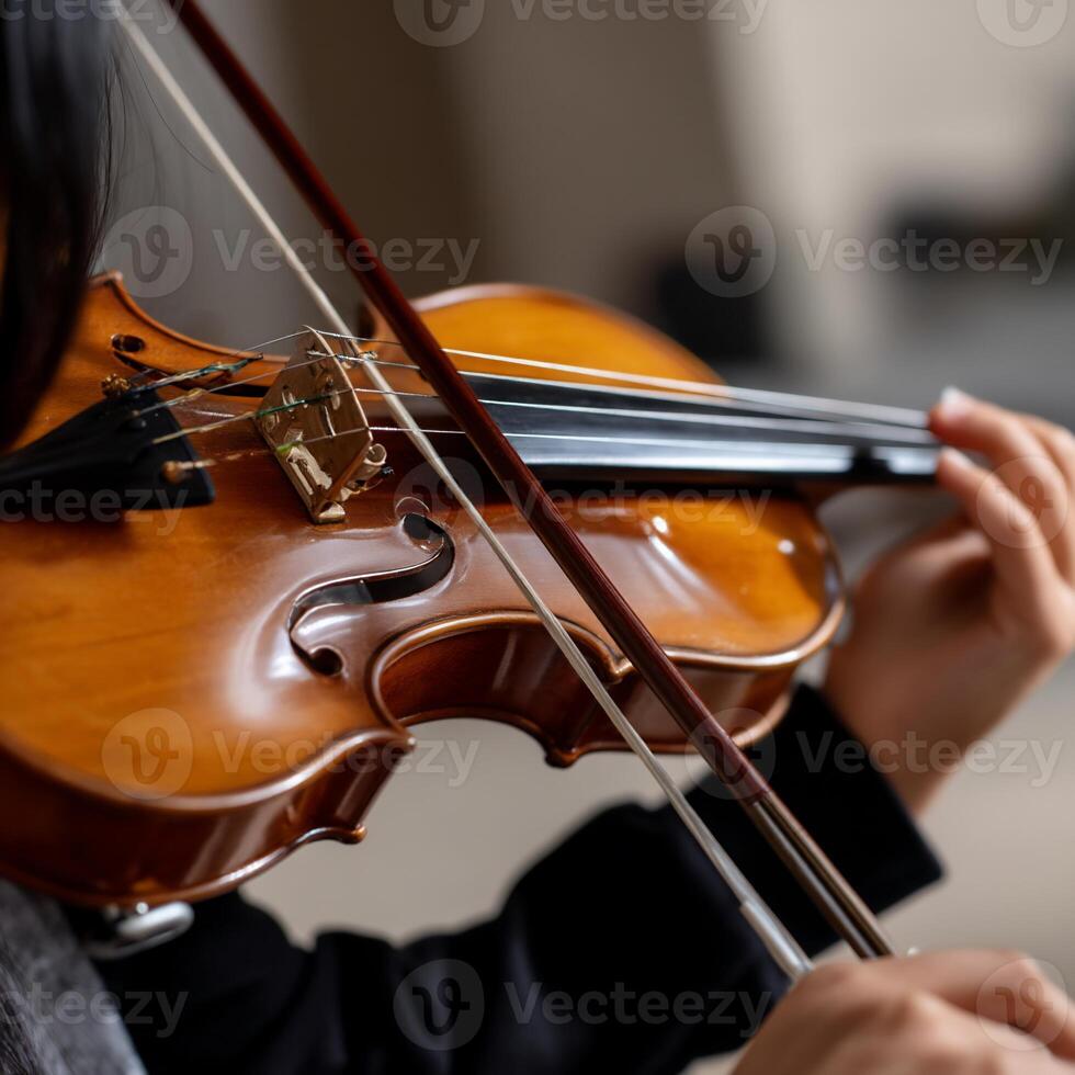 A woman is playing a violin in a room photo