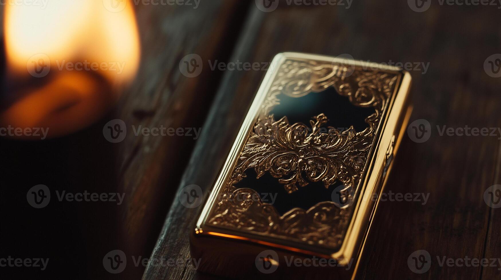 A gold lighter sitting on a wooden table next to a candle photo