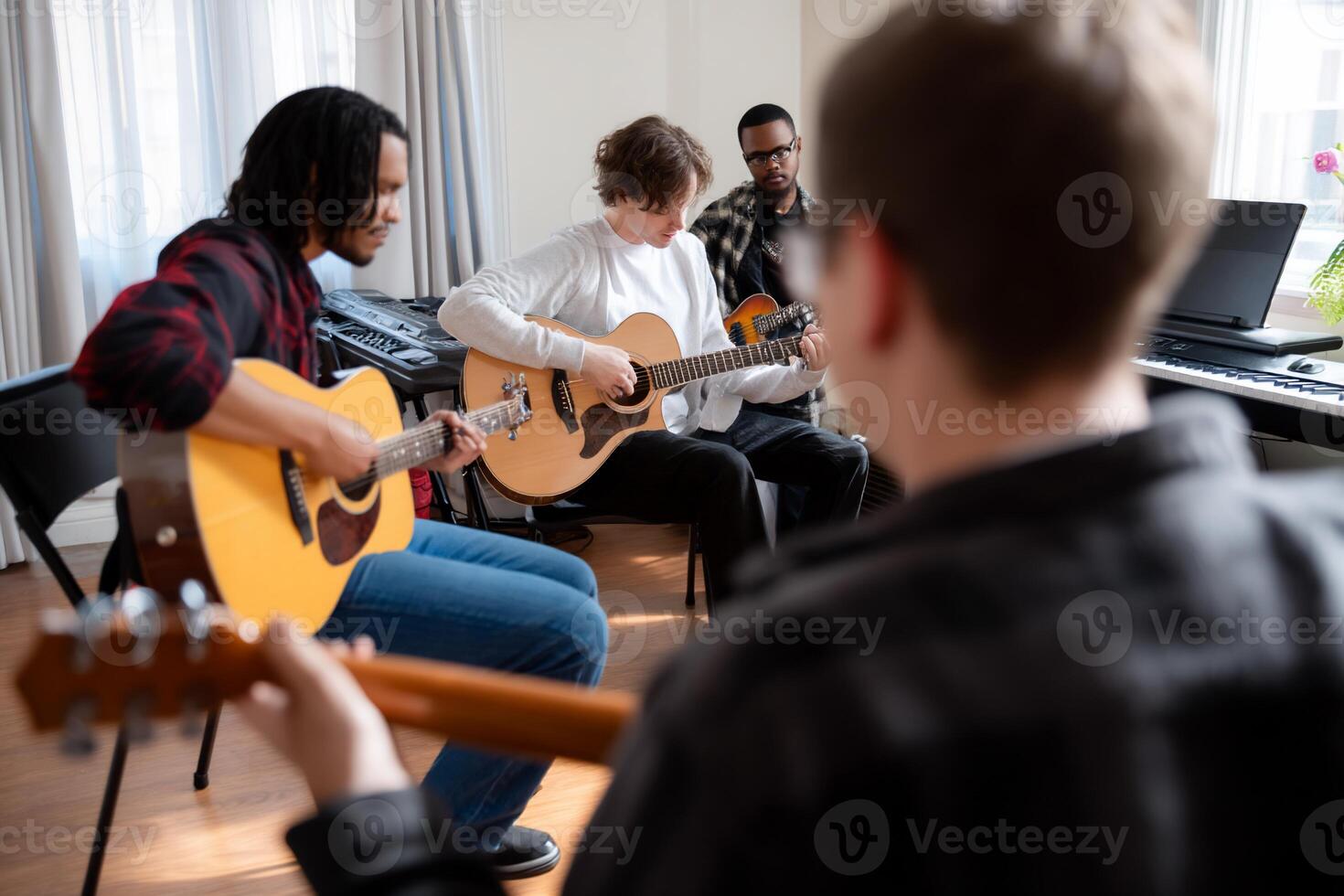 Diverse group of young musicians playing acoustic guitars in a music lesson photo