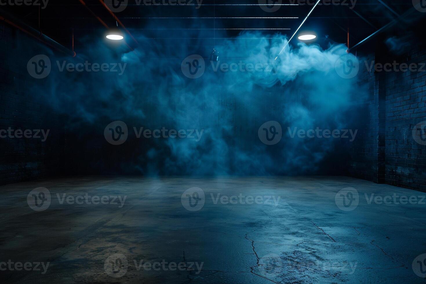 Dark, industrial space filled with blue smoke. Concrete floor, brick walls, and spotlights illuminate the scene photo