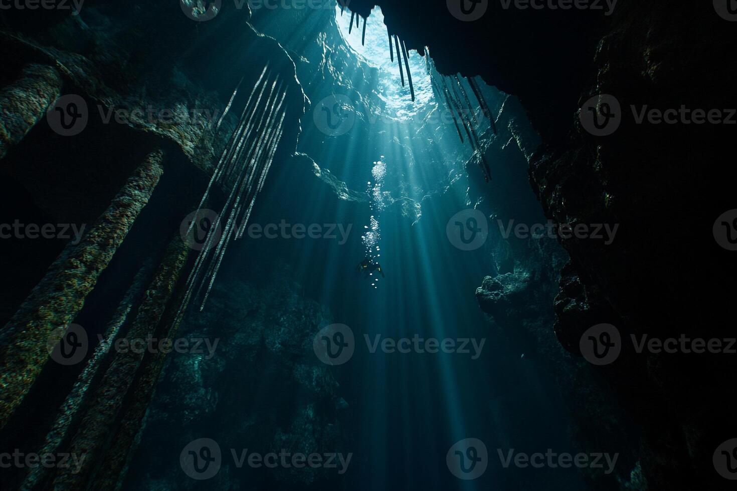Sunbeams illuminate a deep underwater cave, showcasing a diver photo