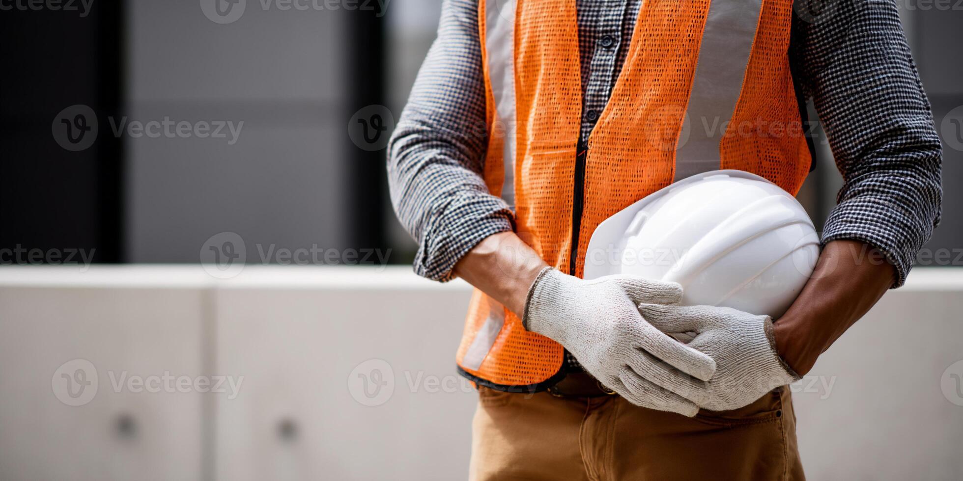 Construction worker holding safety helmet and vest photo