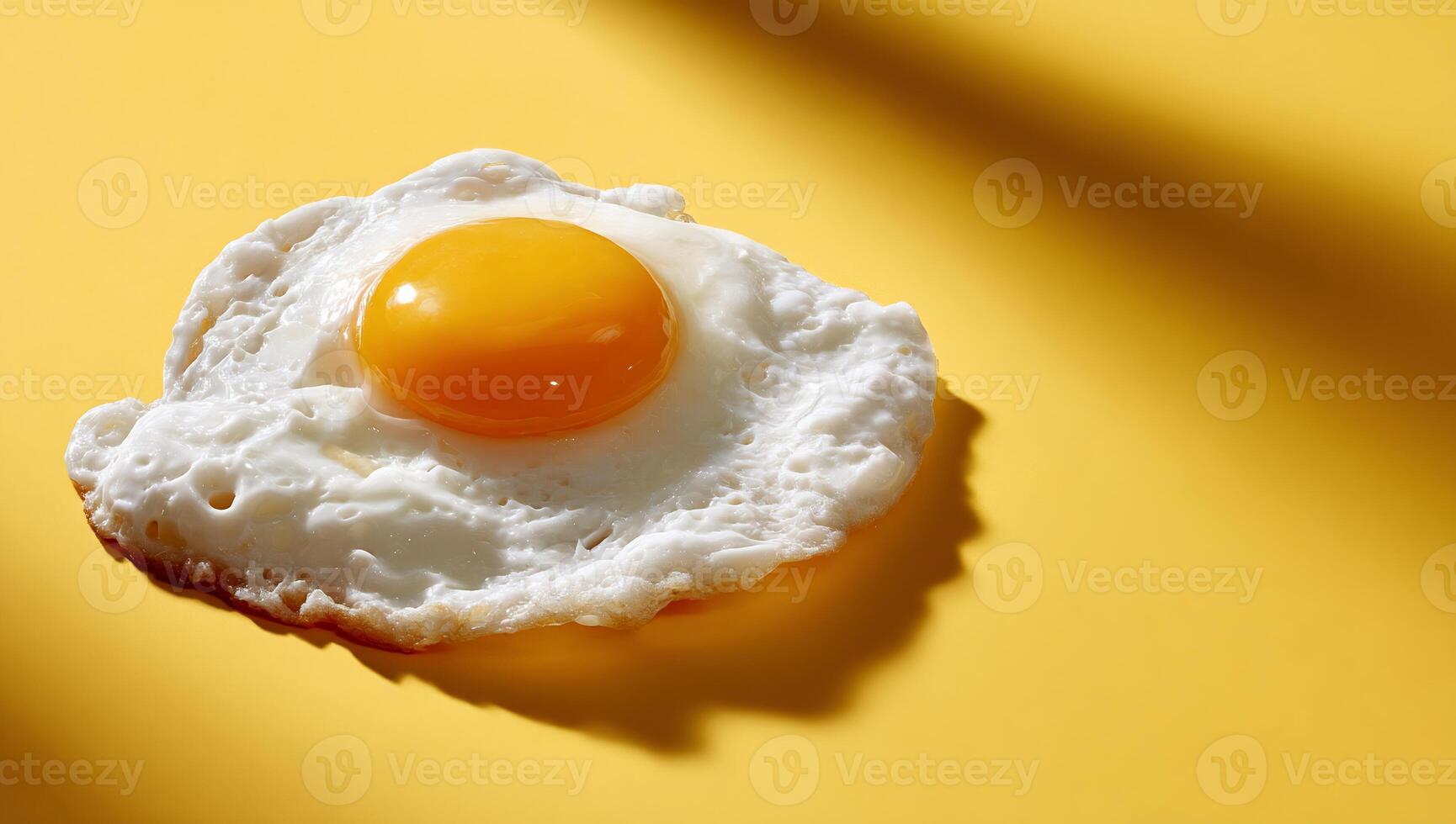 Fried egg on yellow background, cooked yolk and white photo