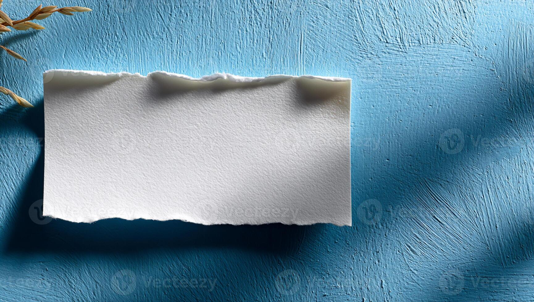 Blank white paper tear on textured blue surface photo