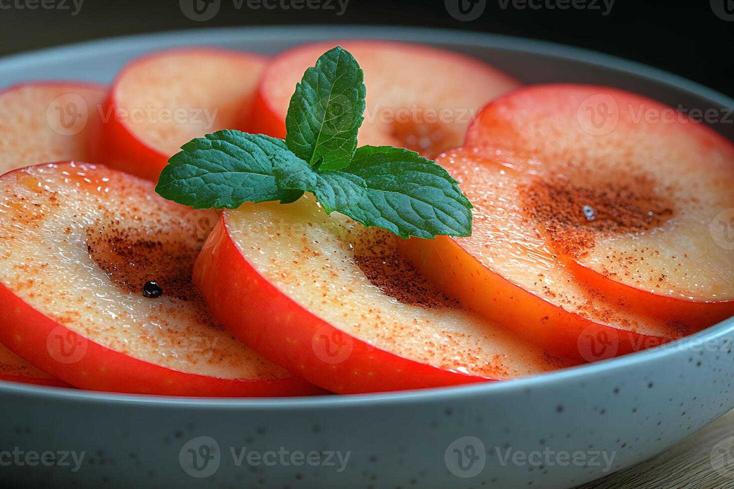Fresh Apple Slices with Cinnamon and Mint Garnish in Speckled Bowl photo
