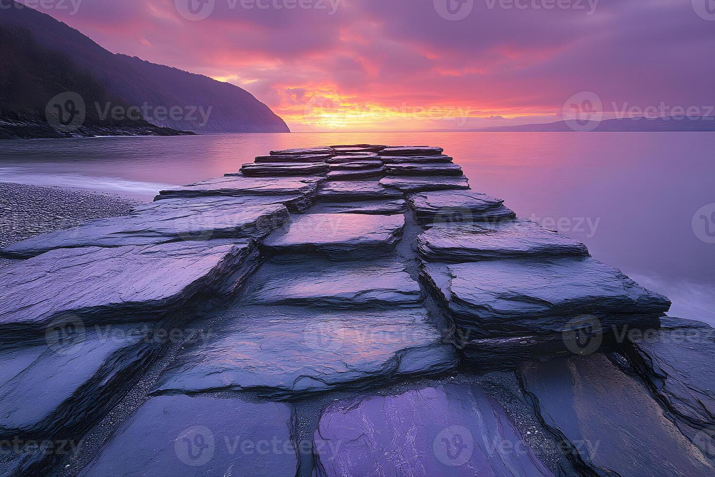 Dramatic Sunset Over Layered Rocks by the Sea for Tranquil Nature Scenes photo