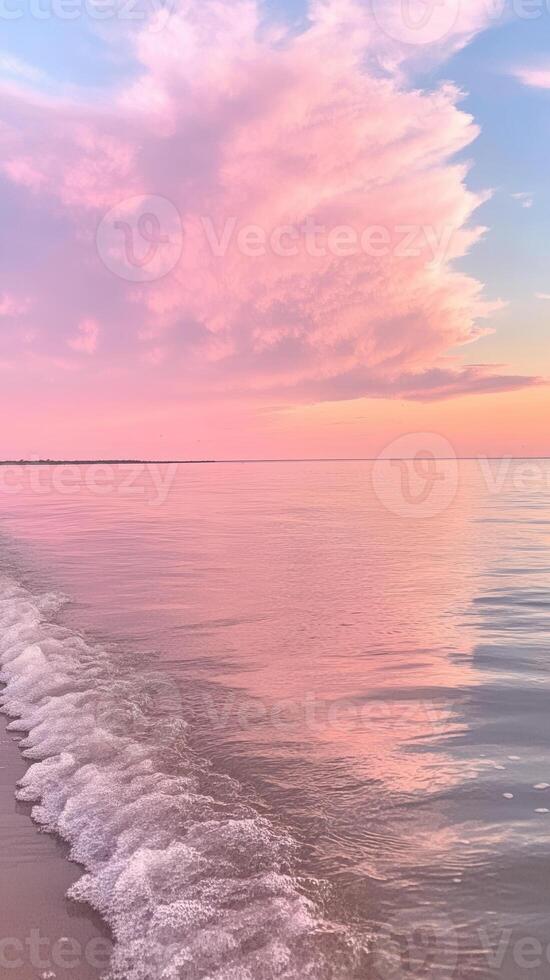 Soft pastel pink sunset reflecting on calm ocean water with gentle washing wave ashore. Abstract background photo
