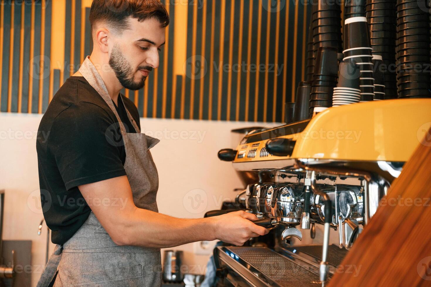 Pours a drink, by ,,using special machine. Man is serving delicious street food photo