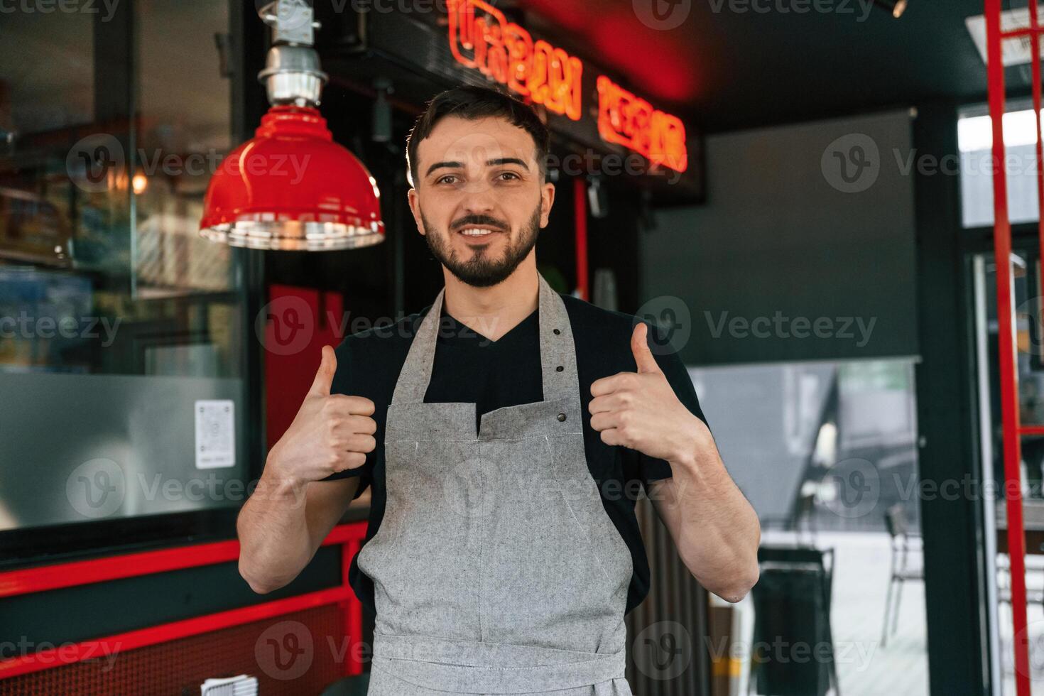 Thumbs up. Man is serving delicious street food photo