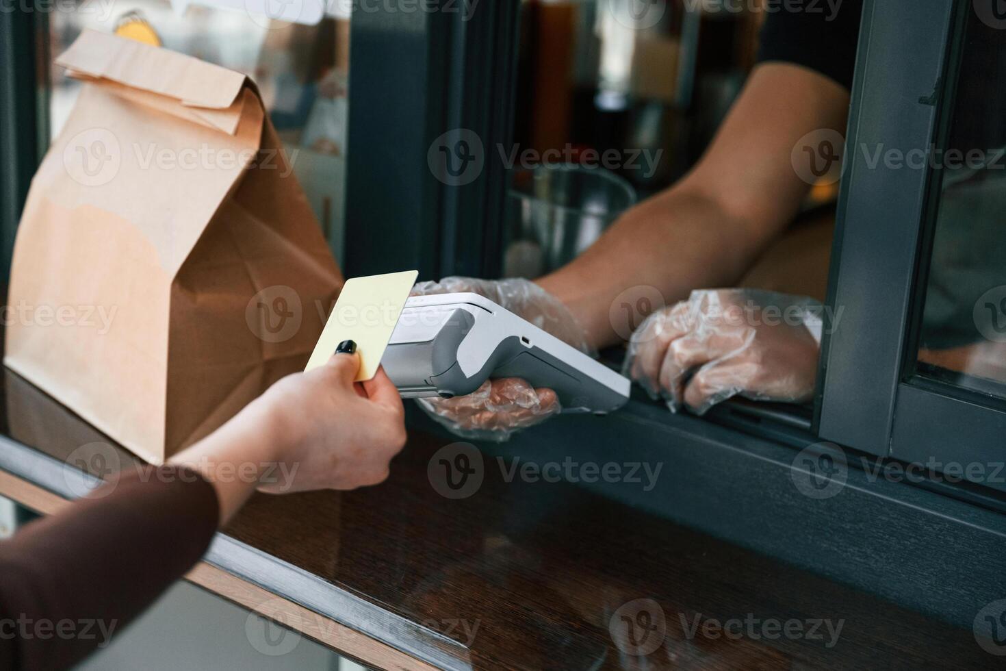 Customer is making payment ,by, credit card. Man is serving delicious street food photo