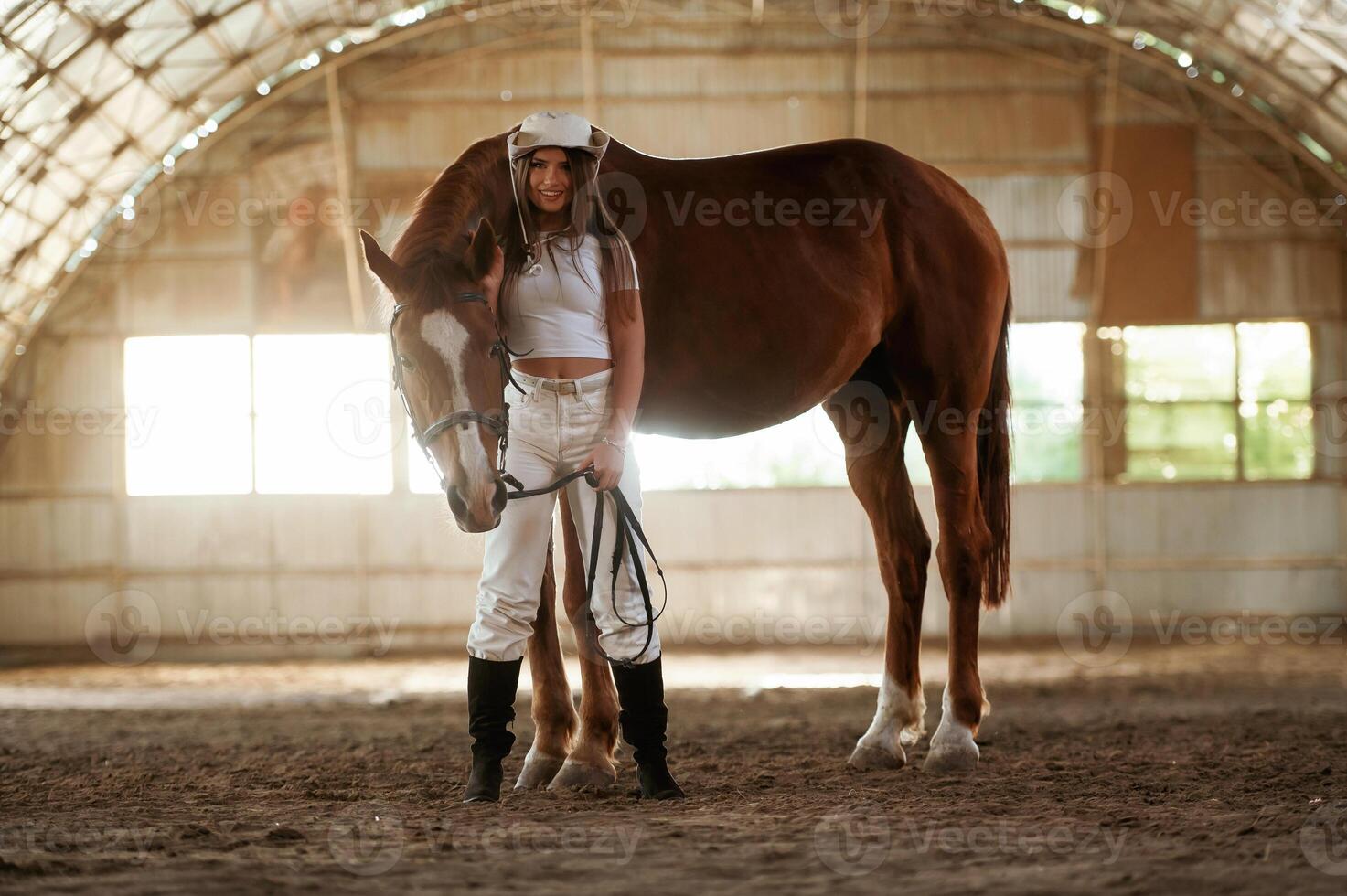 In the cowboy hat. Beautiful ,young ,woman is with horse indoors photo