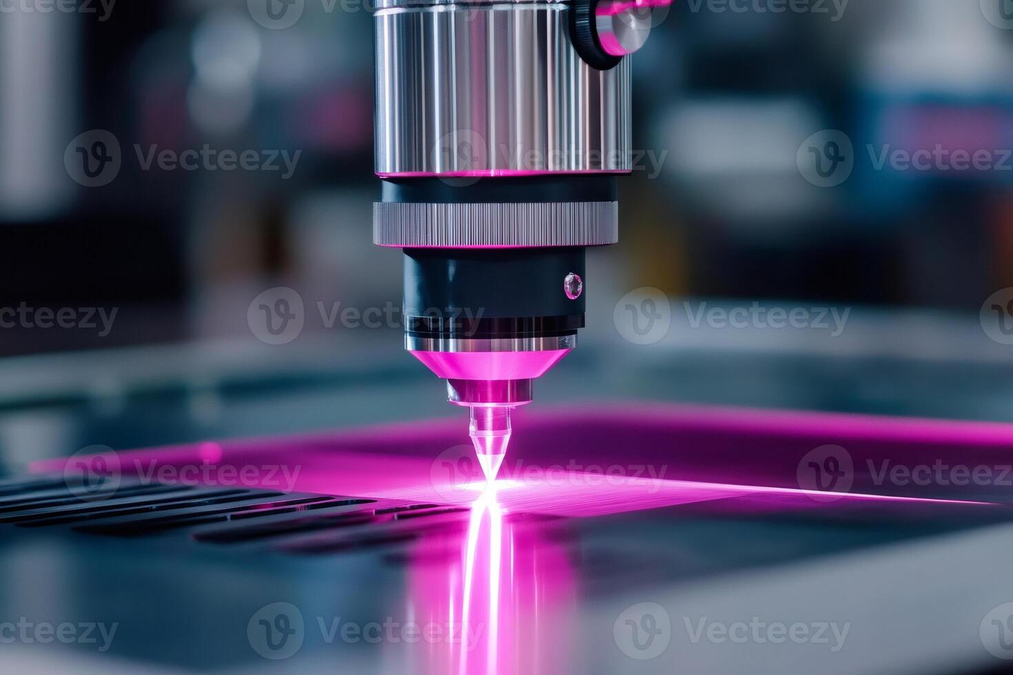 Laser engraving machine working on metal plate with pink light photo