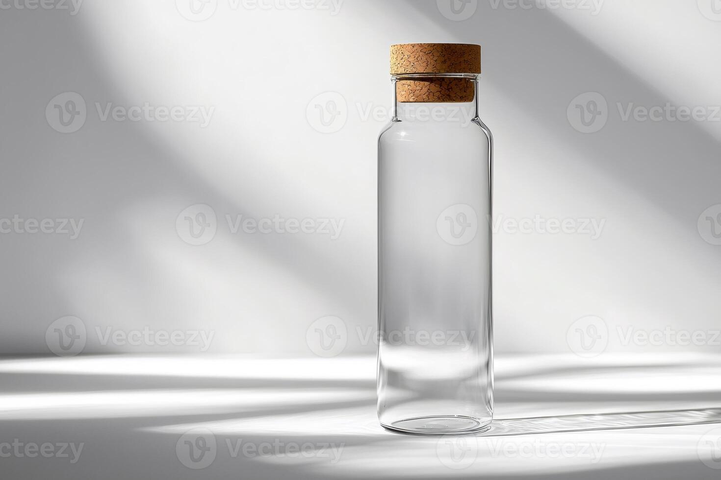 Empty glass bottle with cork lid on white background casting shadows photo