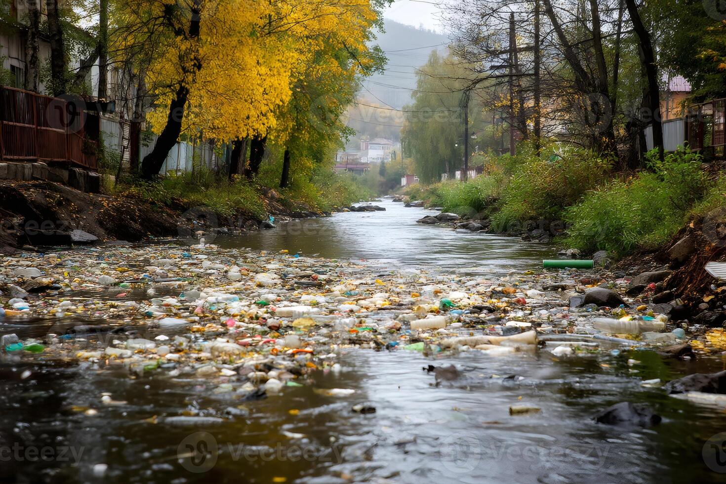 Plastic garbage polluting water in river near residential area in autumn photo
