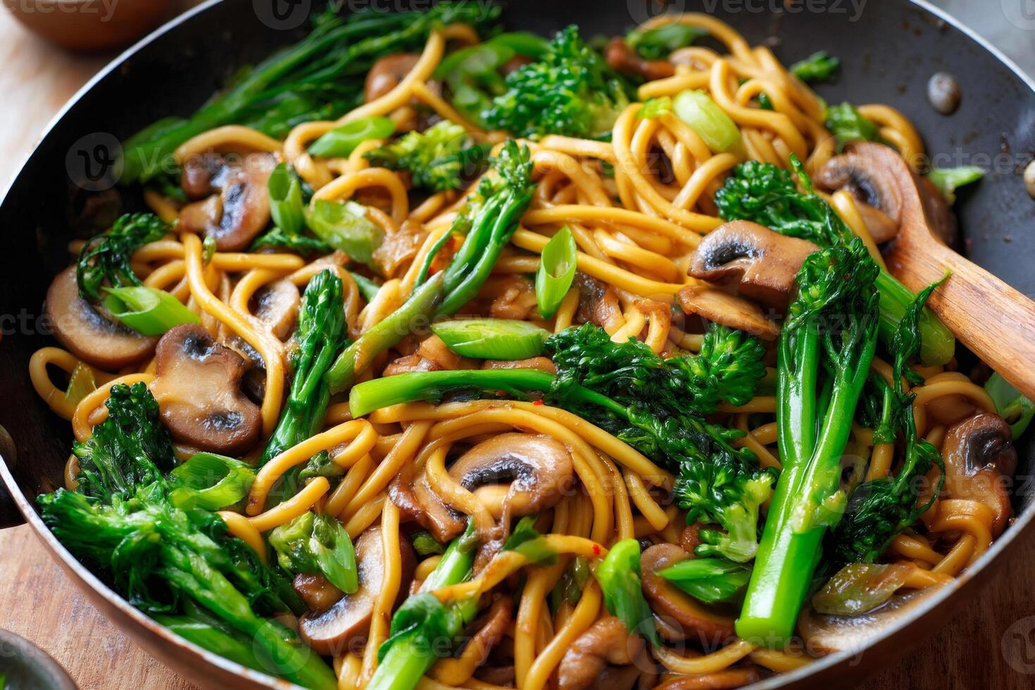 Egg noodles stir fry with mushrooms and broccolini in a pan photo
