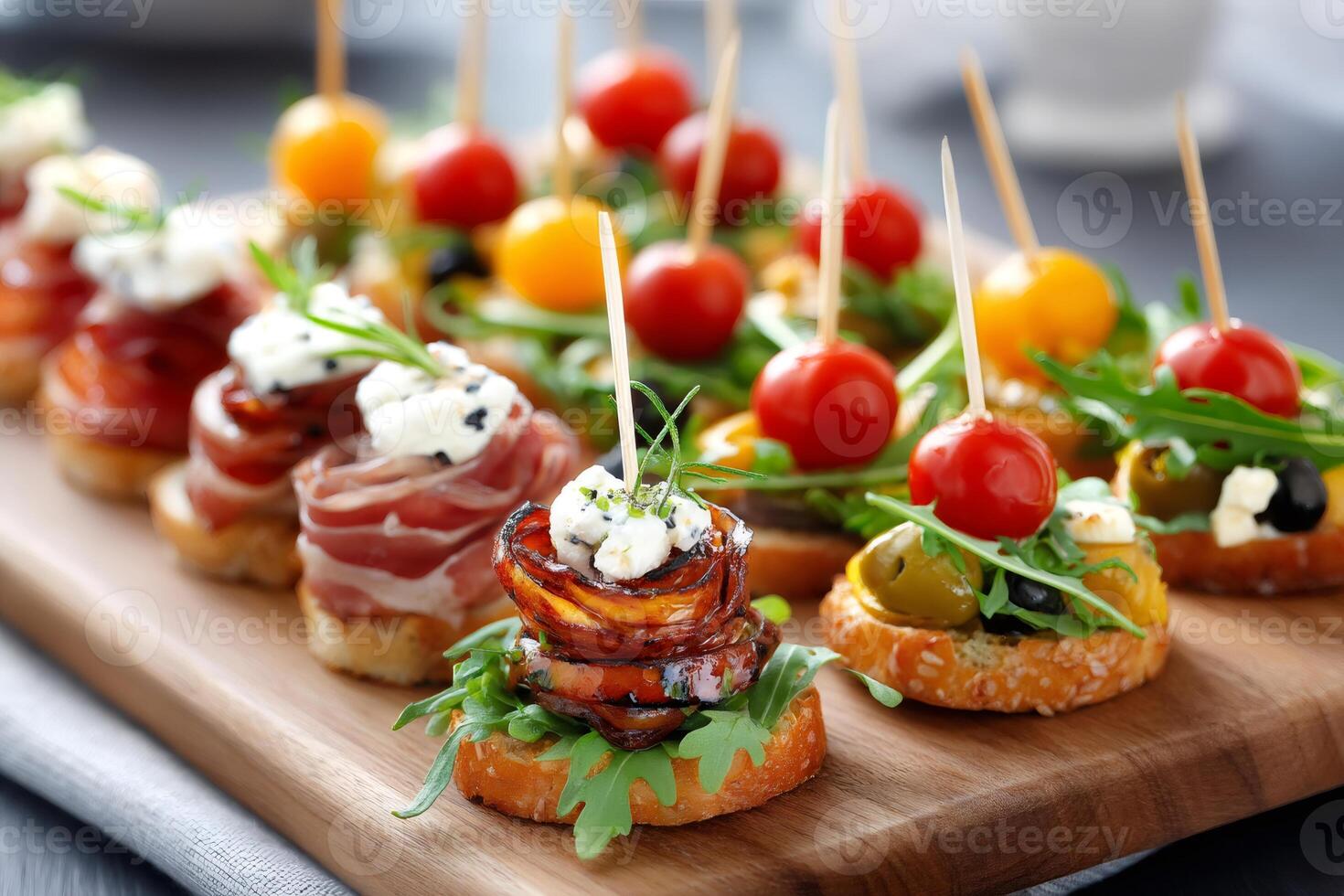 Delicious canapes with tomatoes, olives, cheese, parma ham and herbs decorating a wooden board photo
