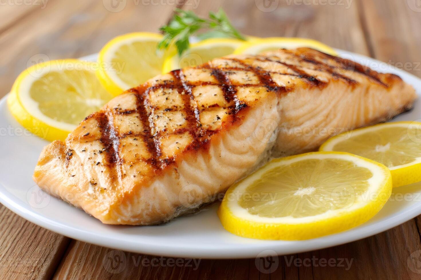 Grilled salmon fillet with lemon slices on white plate photo