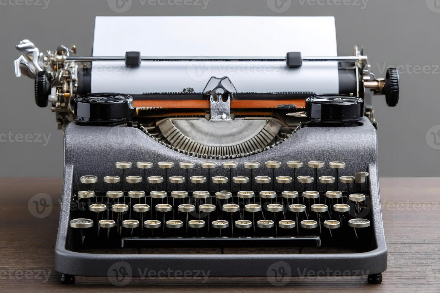 Vintage typewriter standing on wooden desk with blank paper inserted photo