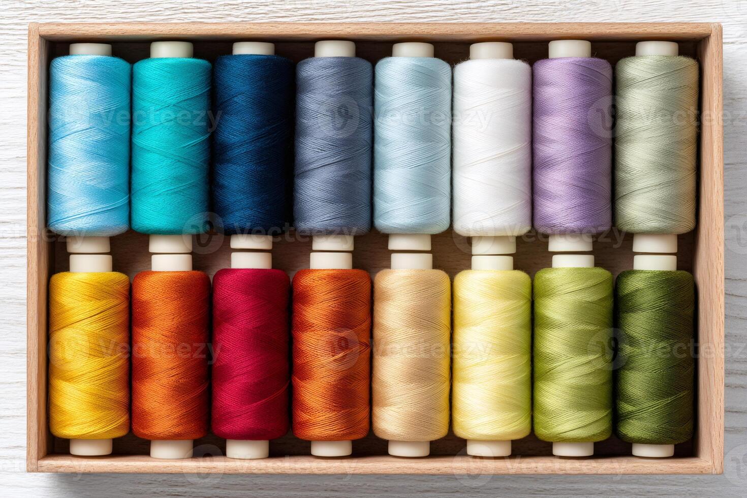 Colorful sewing threads arranged neatly in wooden box for tailoring and fashion design photo