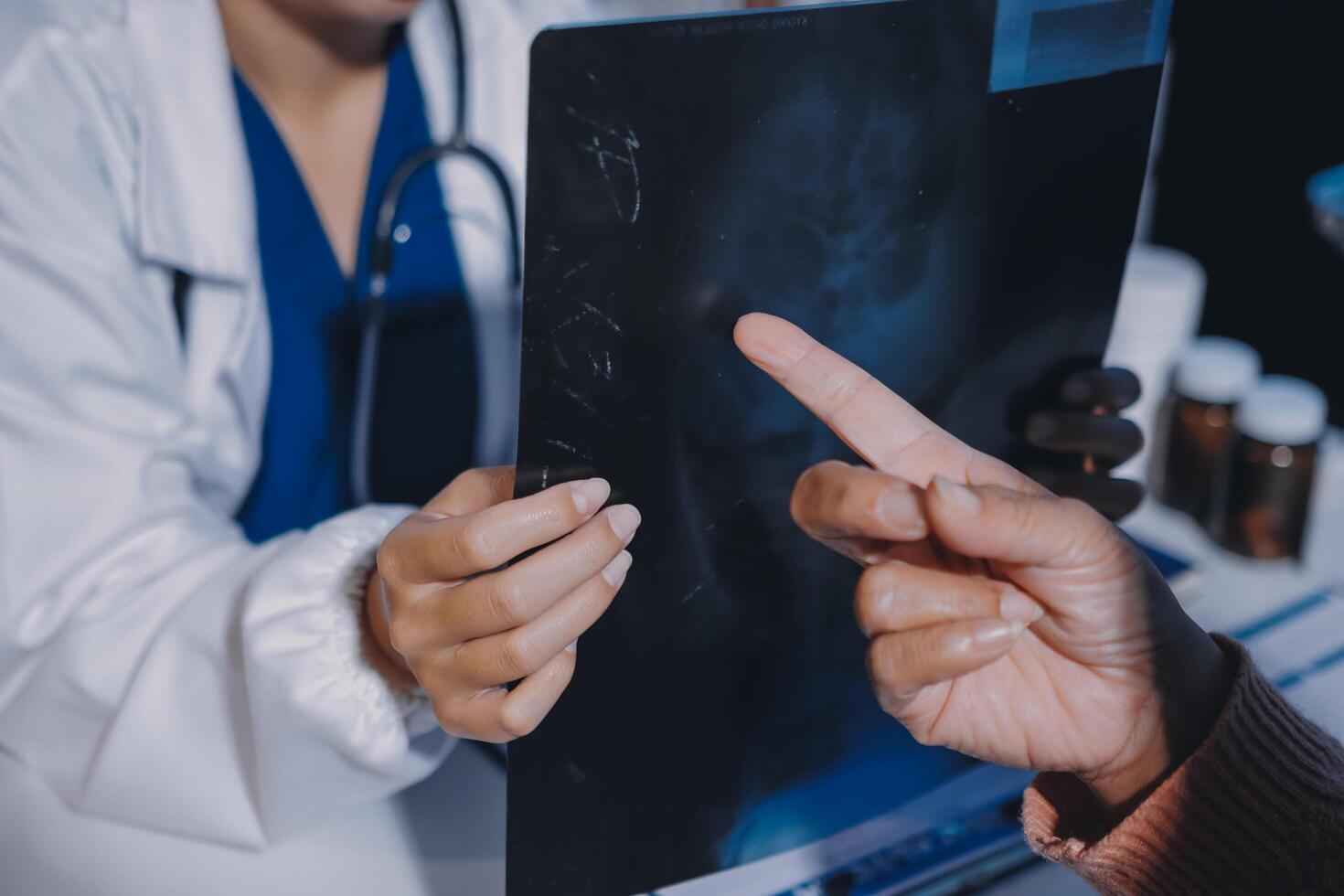 A doctor pointing to a patient's x - ray photo