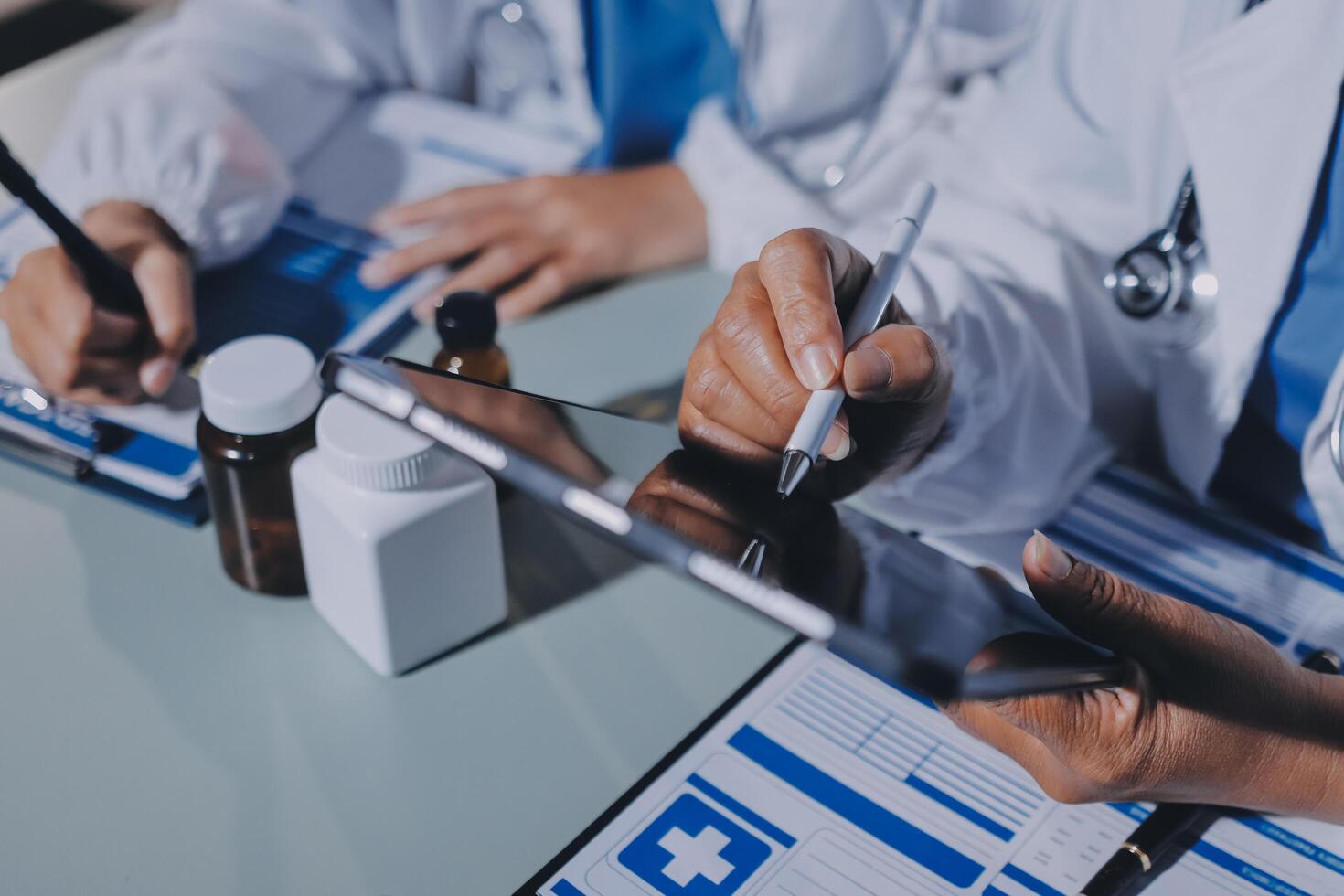 Doctors working on a tablet with a pen and paper photo