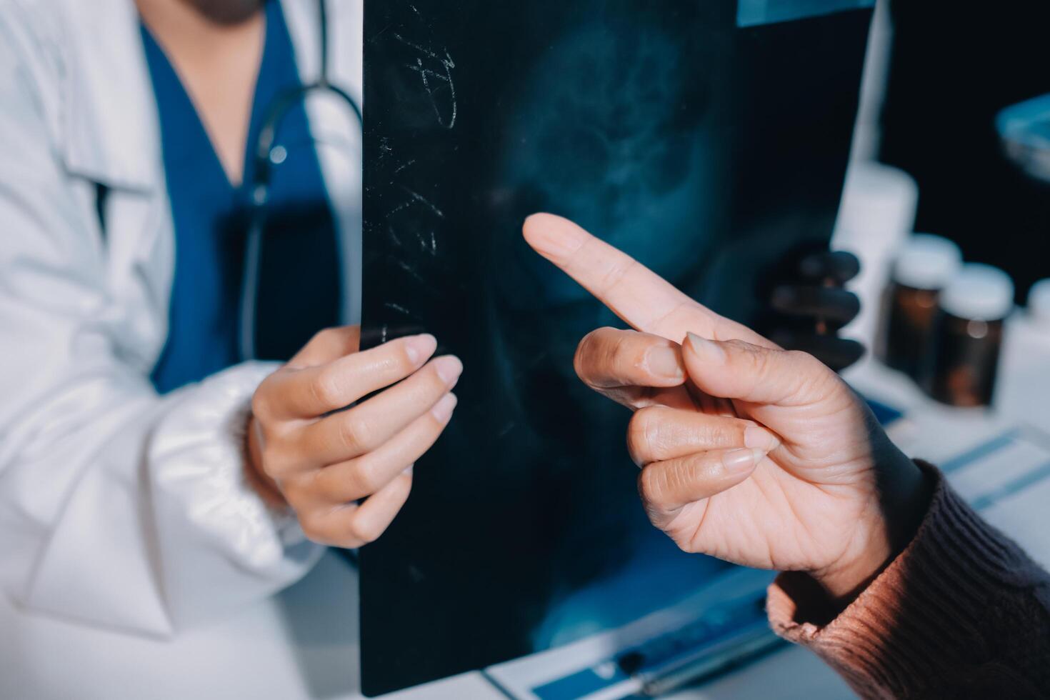 A doctor pointing to a black and white image on a screen photo