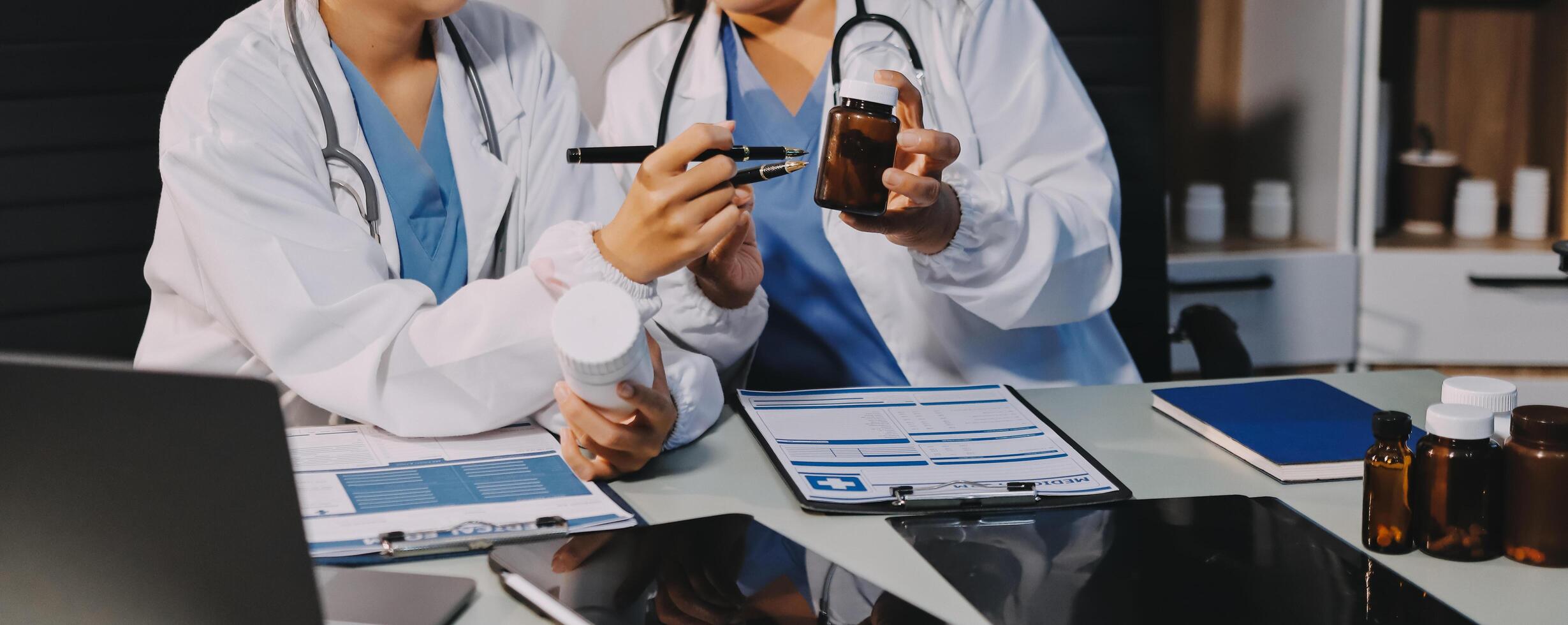 Two doctors looking at a tablet computer and a bottle photo