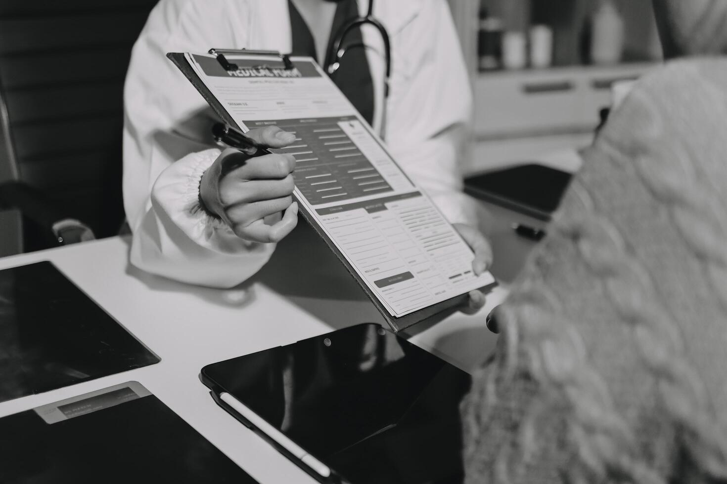 A doctor is holding a clipboard while looking at a patient photo