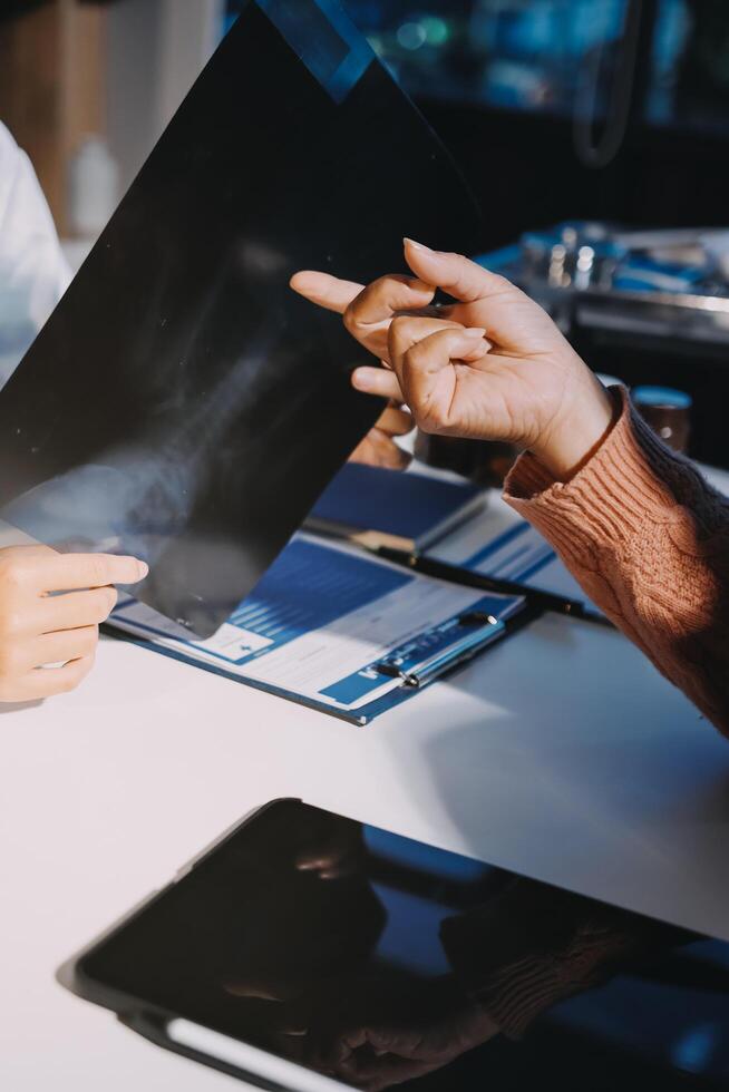 Two people sitting at a table with a laptop and a piece of paper photo