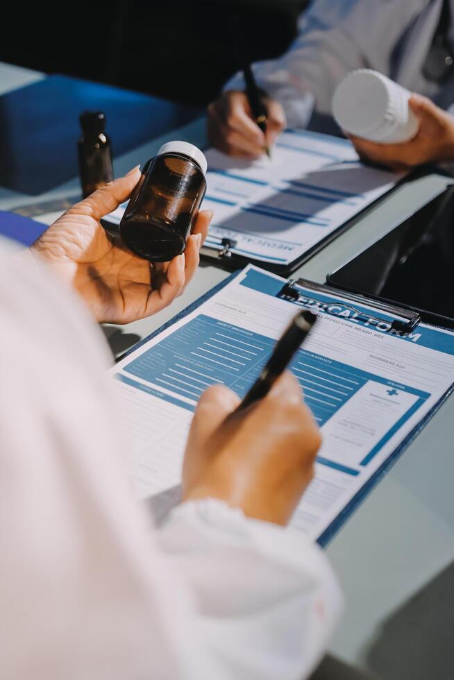 A doctor is holding a pen and paper while sitting at a table photo