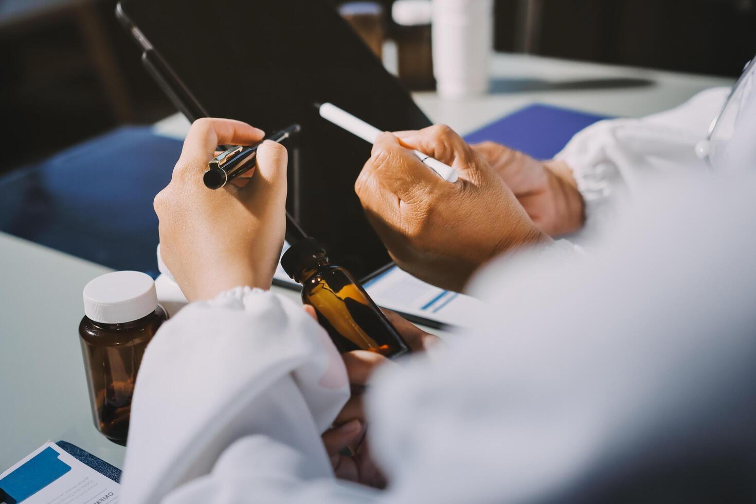 A person in a lab coat is writing on a tablet photo