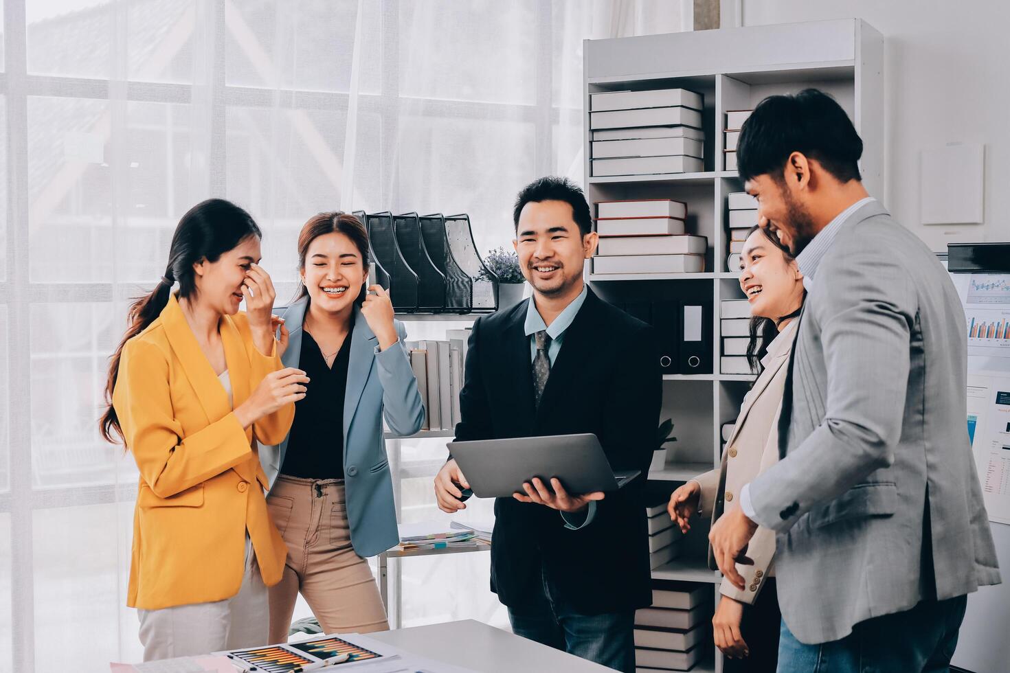 Business people standing in an office talking and smiling photo