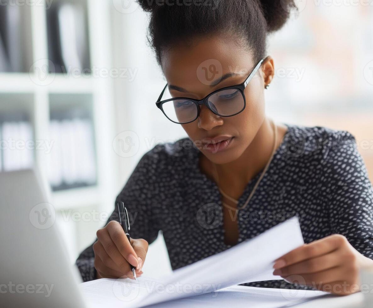 Focused individual studies documents while working at a desk photo