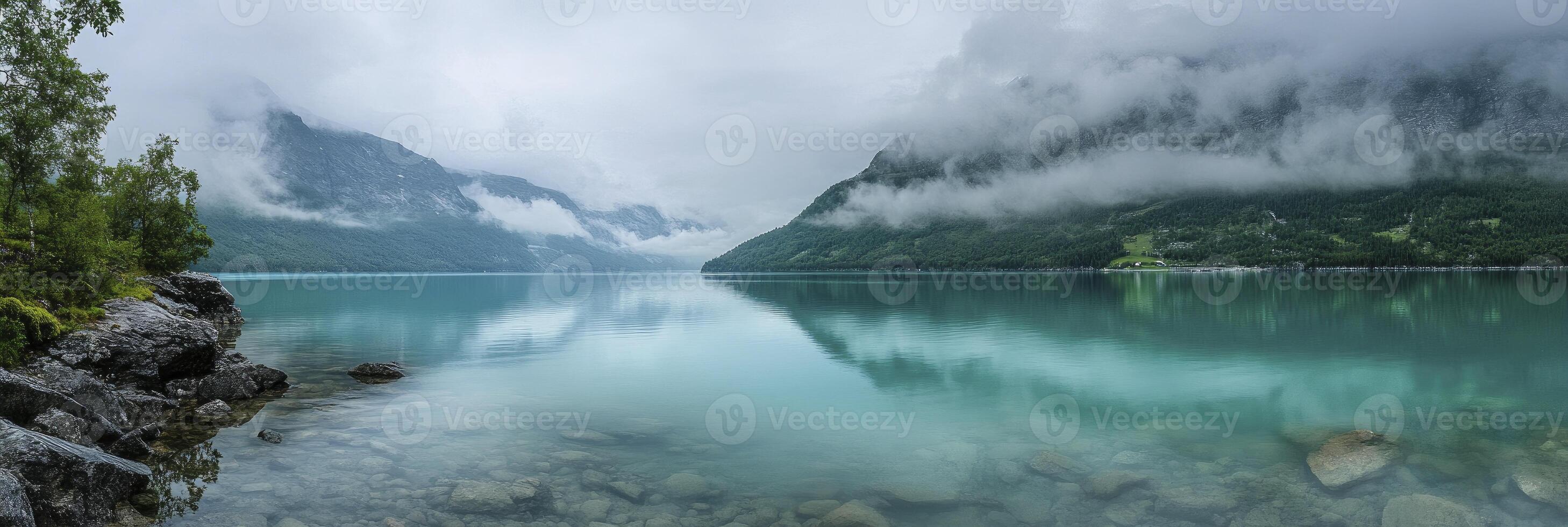 A lake surrounded by mountains and trees photo