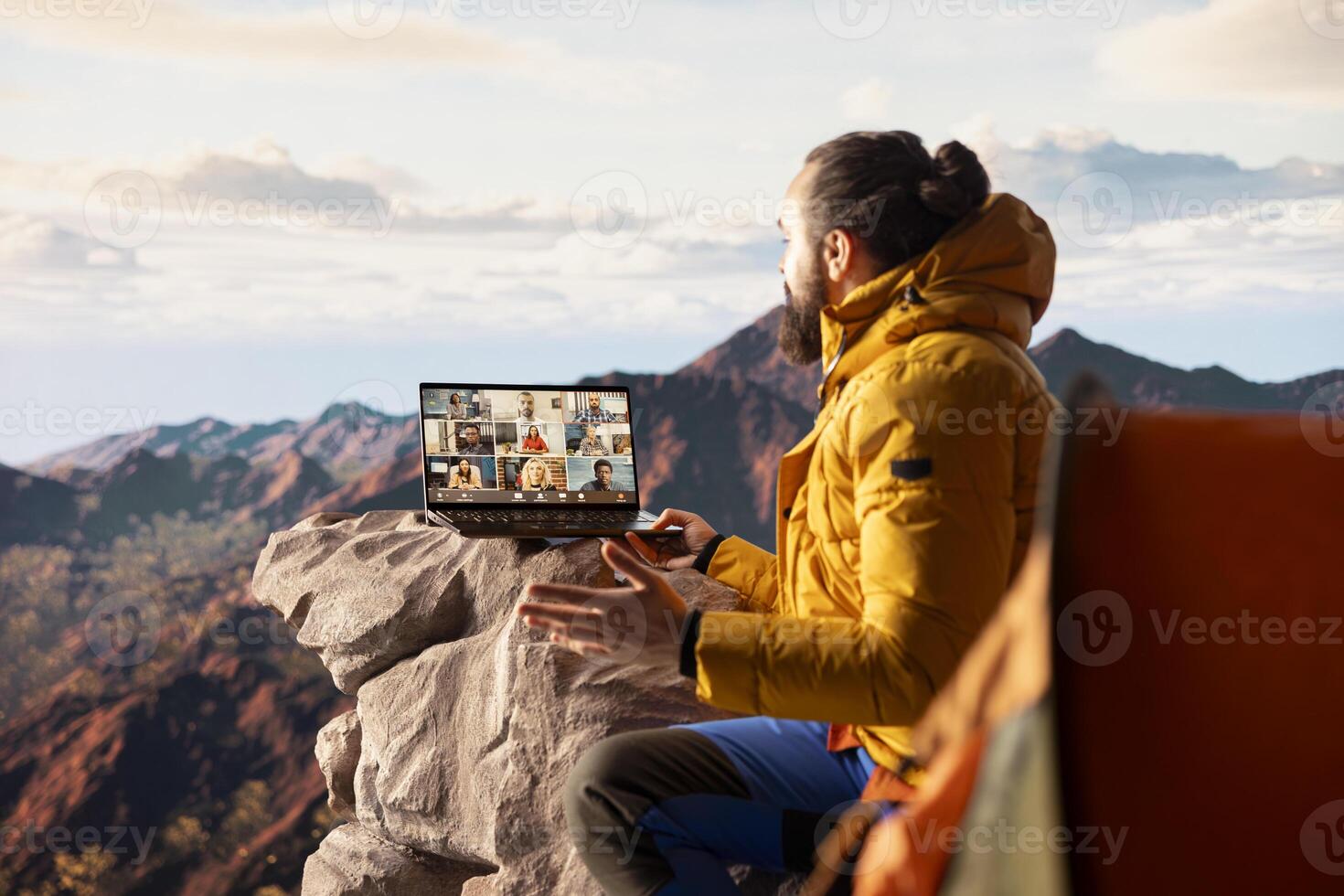 Entrepreneur uses high speed internet connection on mountain top, enjoying the call with a scenic landscape. Young hiker having an internet dependency and being workaholic. photo