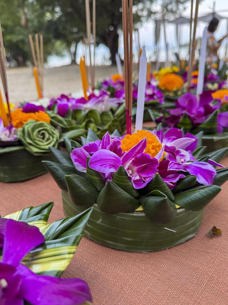 Bangkok, Thailand - November 10, 2024. Floral arrangements placed on tables, part of sacred ritual where flowers and floating candles drift on water. Devotion and blessings in a cultural ceremony. photo