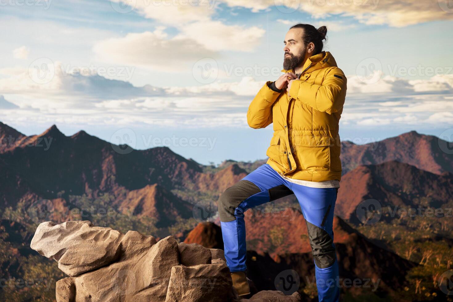Male explorer embraces the solitude of high altitude wilderness, climbing on top of the mountain for fresh air and a scenic background. Mindfulness and relaxation in the nature. photo