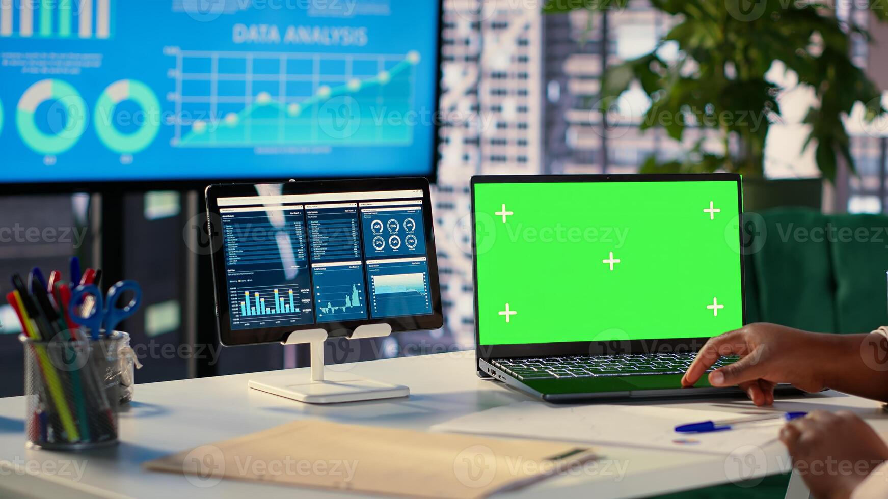 Young general manager using green screen on laptop and evaluating performance metrics for her staff, conducting a planning session. African american CEO shows leadership skills. Camera A. photo