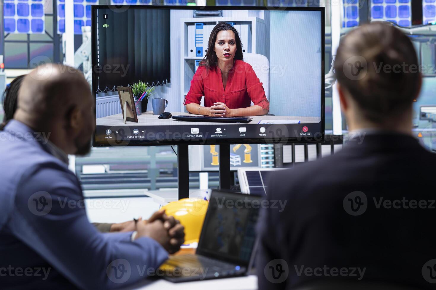 Compliance officer aids shareholders in assessing laws compliance during teleconference meeting. Investors in industrial plant examine financial statements and evaluate assets during online videocall photo