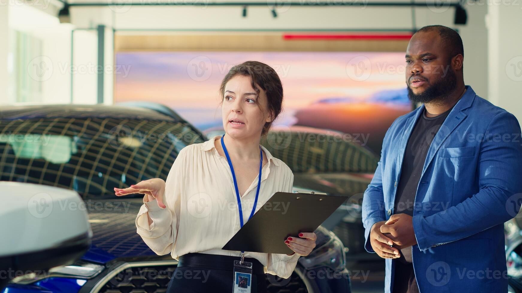 Saleswoman in dealership negotiating price and extra car features to help solidify deal, earning commission bonuses on every sale. Agent persuading hesitant customer to buy vehicle, camera A photo