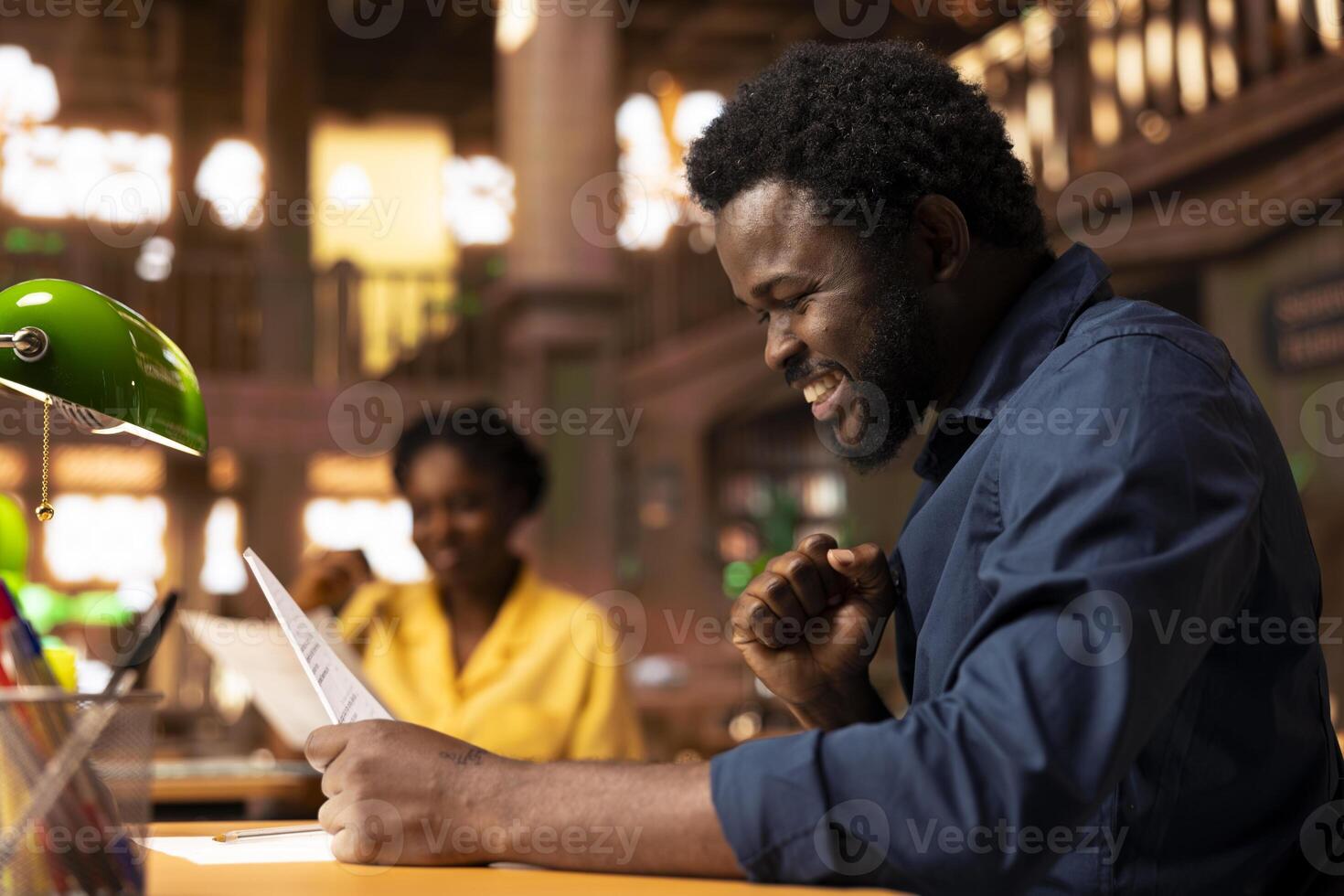 Determined pupil preparing for exams at the campus library, using educational resources like books, notes and research papers for complete information. Quiet environment for productivity. photo