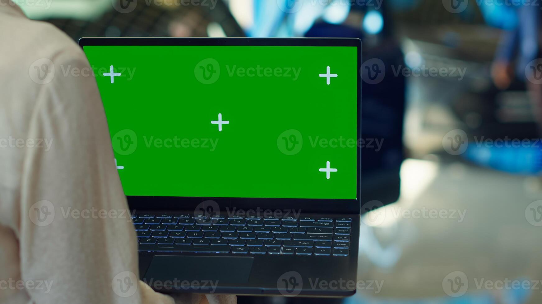 Customer in showroom looking for new vehicle to purchase or lease using green screen laptop. Woman evaluating automobiles in dealership before buying using chroma key notebook, camera A photo
