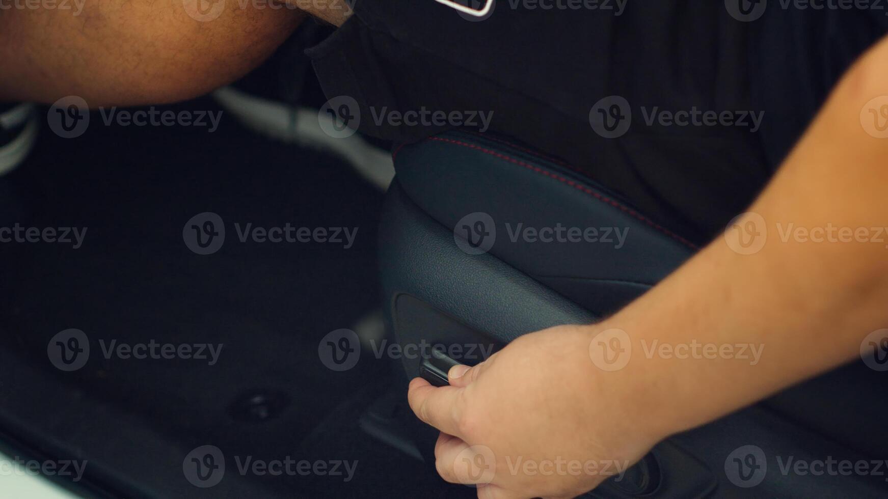 Close up of man in car adjusting driver seat using buttons. Person in vehicle chair that can be raised, lowered, tilted, moved forwards and backwards to suit the comfort of driver photo
