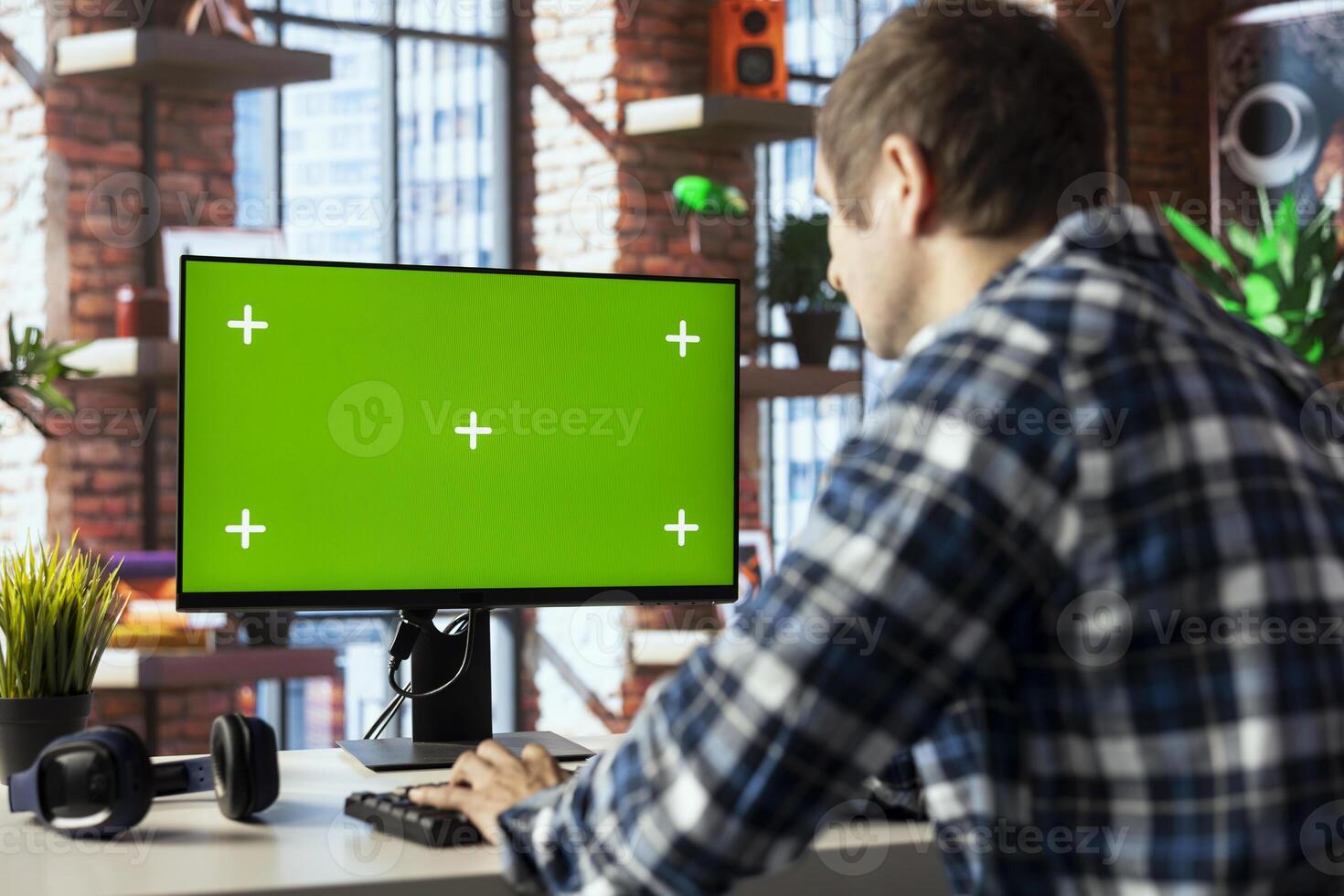 Teleworker in home office using chroma key computer display to answer emails from business associates. Man typing on green screen device keyboard, solving tasks in apartment photo