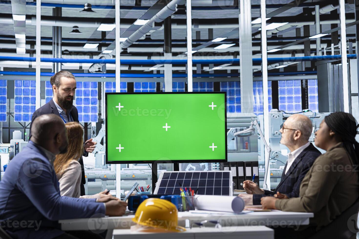Investors interested in factory analyzing revenue streams on green screen monitor. Businesspeople in industrial plant look at mockup display to forecast returns, factoring in growth scenarios photo