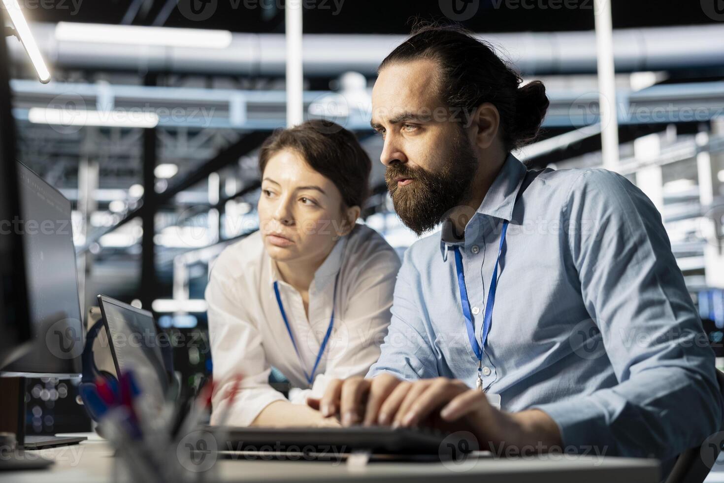 Data center coworkers doing brainstorming, running diagnostic scripts on computer, examining hardware. Server room employees talking, working together to evaluate performance metrics photo