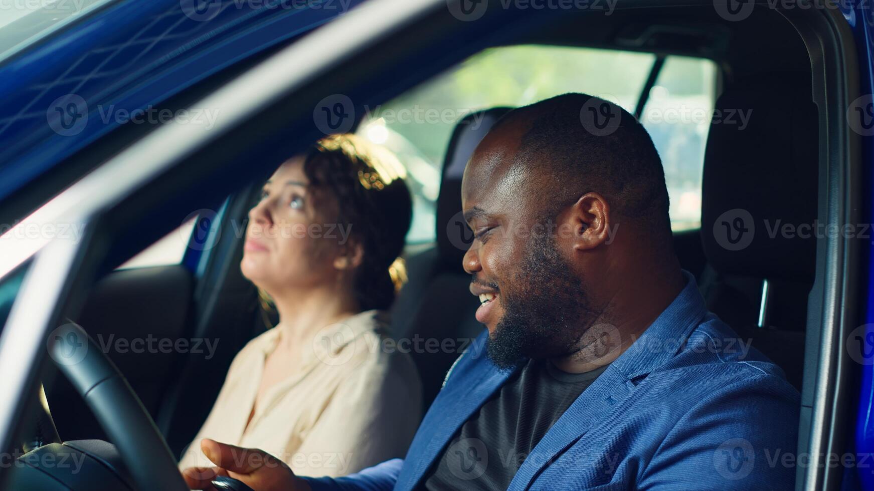 Clients going on test drive before buying car, receiving keys from salesman after being happy with pedals and seat adjustments. Customers evaluate how vehicle feels before buying from agent, camera A photo